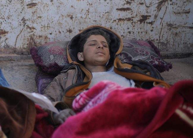 Hareth Najem, an Iraqi orphan lies under a blanket in a truck, near the village of Baghouz, Deir Al Zor province, Syria March 1, 2019.