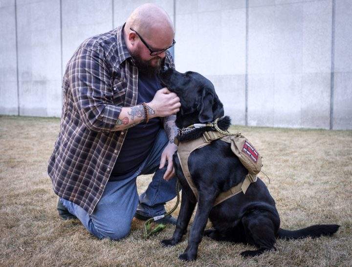 Former Syyncrude firefighter Michael Swan and his service dog Jack in Calgary, Alta., Monday, Jan. 14, 2019. A lawsuit filed by a former firefighter and paramedic against Syncrude Canada claims the oilsands giant wrongfully denied him benefits and fired him after he was diagnosed with post-traumatic stress disorder related to his job.