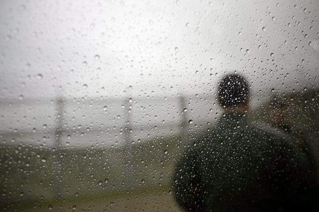 In this Jan 15, 2019 image, a U.S. Border Patrol agent looks towards a border wall as rain drops cover a window in San Diego. 