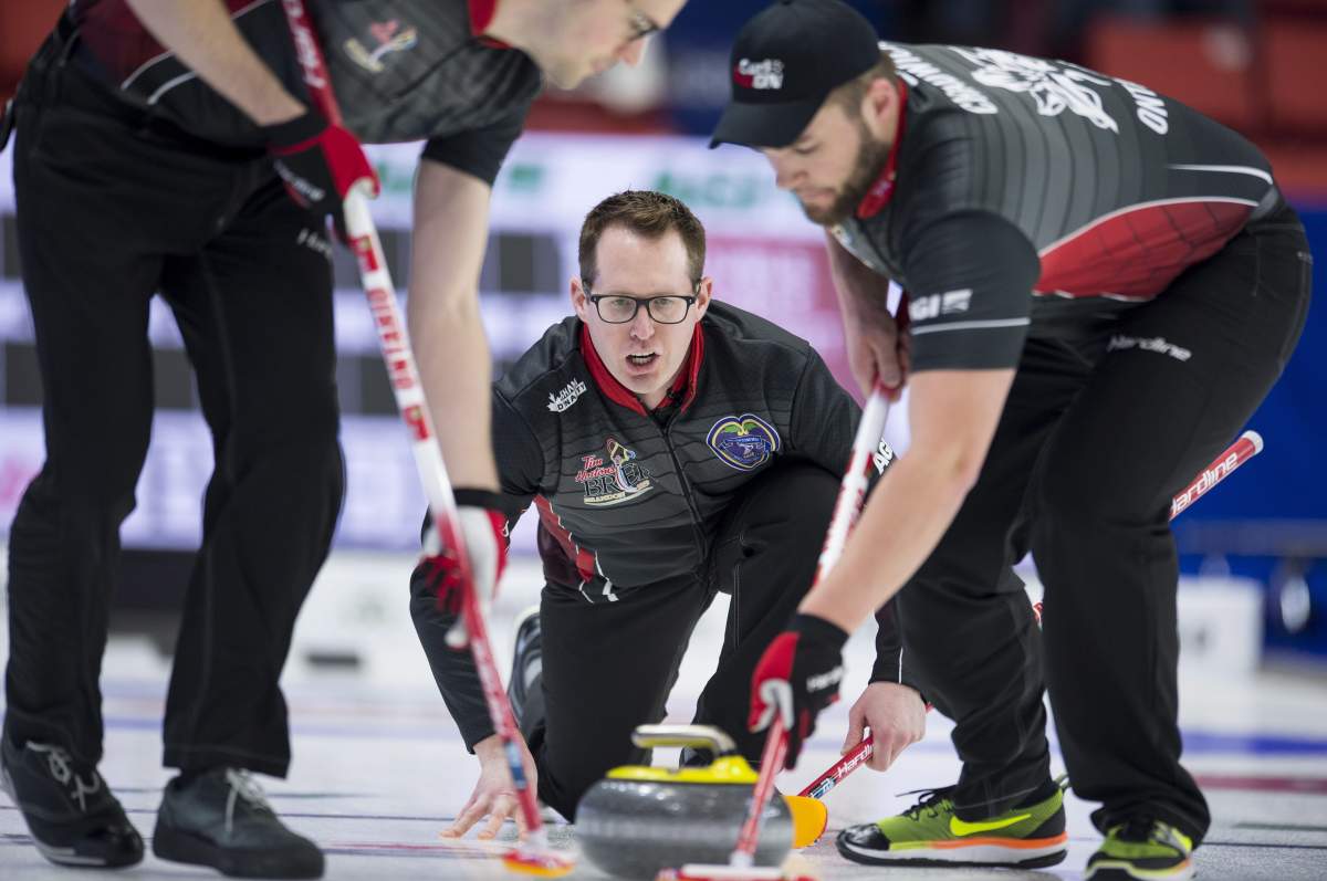 Team Ontario skip Scott McDonald calls his shot as lead Scott Chadwick and second Wesley Forget sweep during the 16th draw against team Saskatchewan at the Brier in Brandon, Man., Thursday, March, 7, 2019.