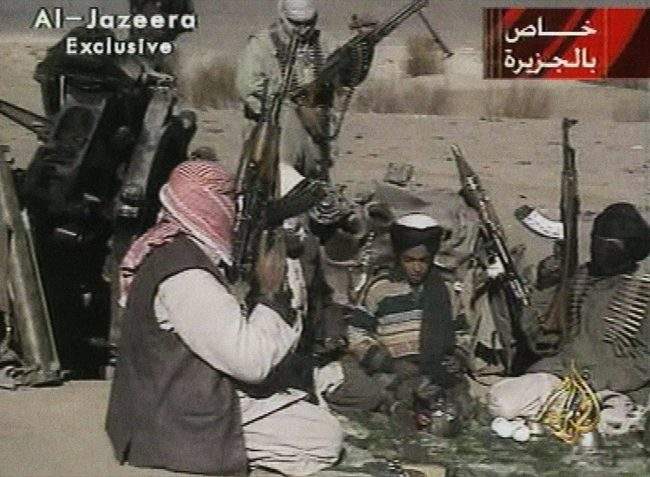 In this Nov. 5, 2001 image made from video broadcast by the Qatari-based television station Al-Jazeera, a young boy, center, identified as Hamza bin Laden, reads a poem about Taliban leader Mullah Mohammad Omar in Ghazni, Afghanistan.