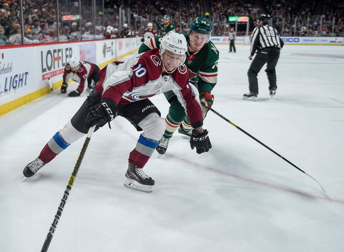 Colorado Avalanche right wing Sven Andrighetto reaches into the corner for the puck as he is chased by Minnesota Wild defenseman Nick Seeler during the second period of an NHL hockey game Tuesday, March 19, 2019, in St. Paul, Minn. Avalanche won 3-1. (AP Photo/Craig Lassig)