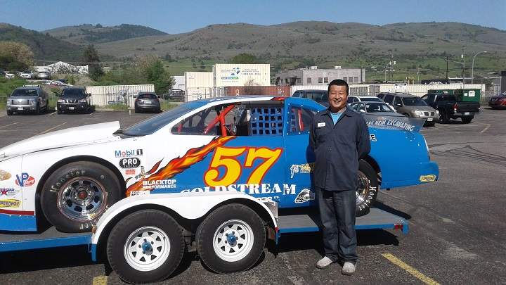 Chunming (Jack) Wang in front of a stock car.