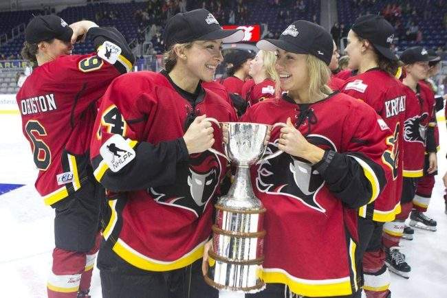 Calgary Inferno’s Zoe Hickel (left) and Tori Hickel celebrate with the trophy after beating Les Canadiennes de Montreal 5-2 to win the 2019 Clarkson Cup game in Toronto, March 24, 2019.