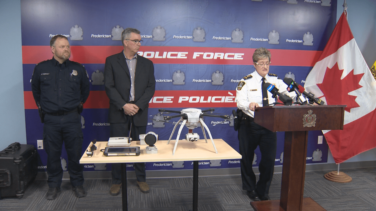 Fredericton police Chief Leanne Fitch (right) unveiling a drone donated by Fredericton-born entrepreneur Stephen Costello (middle) alongside Const. René Theriault, the force’s flight team leader.