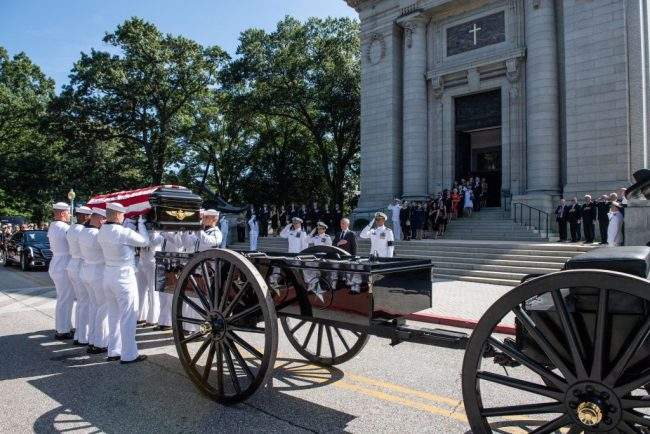 Navy Body Bearers place the casket of the late Sen. John McCain onto a horse-drawn caisson after his funeral service at the United States Naval Academy Chapel, Sept. 2, 2018.