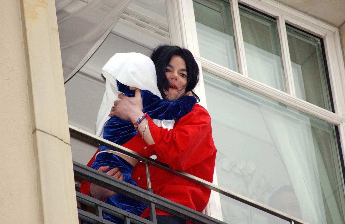 Michael Jackson appears at the balcony of the Adlon Hotel with an unidentified child Nov. 19, 2002, in Berlin, Germany.