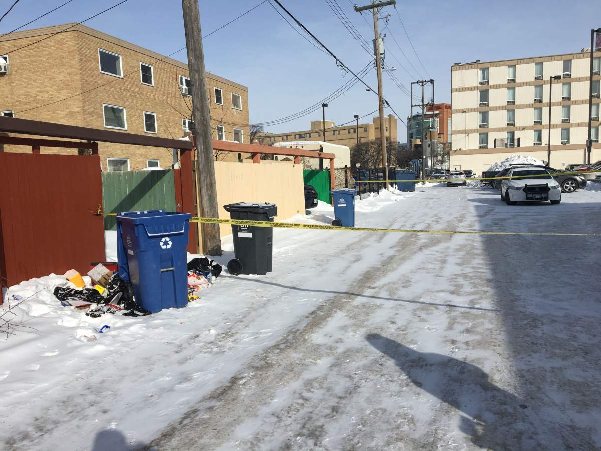 The back alley is blocked off by police tape on McGee Street Monday.