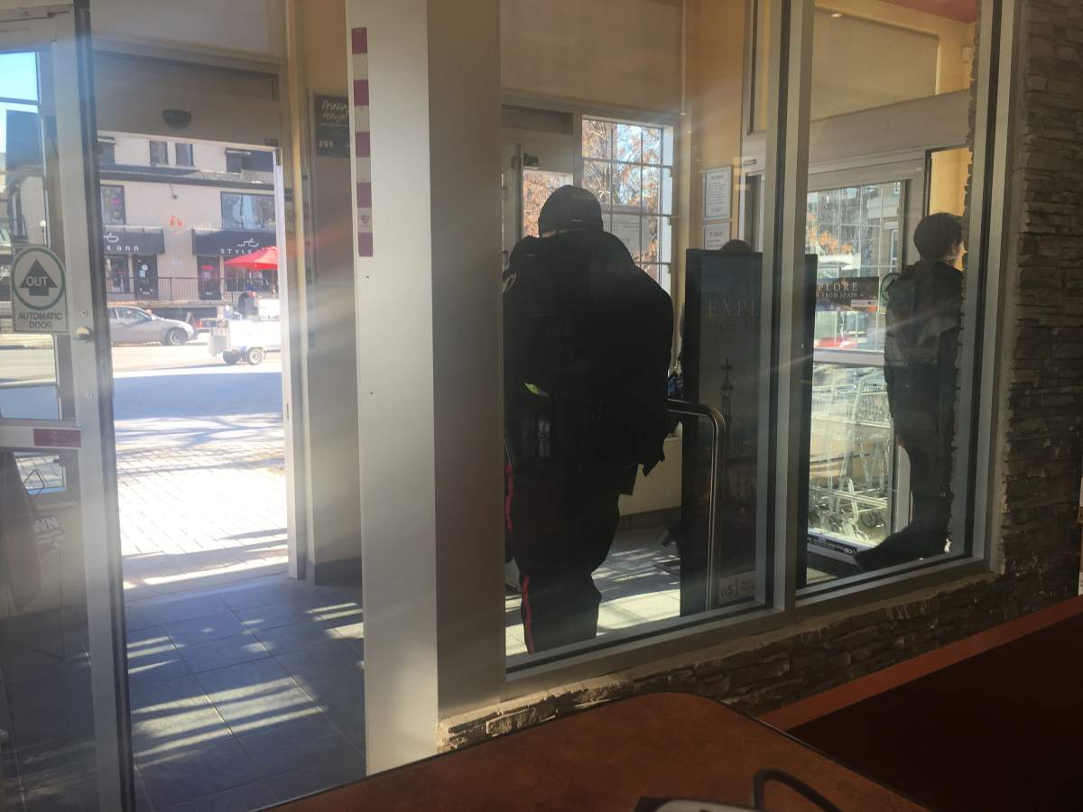 A fully uniformed police officer stationed at the door at the Osborne Village Liquor Mart Friday.