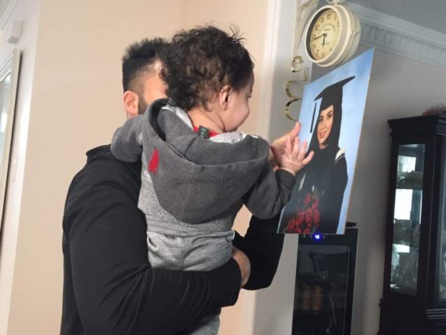Saleem with his one-year-old son Eesa, looking at a photo of his late wife Ayesha Riaz. Photo by Global News.