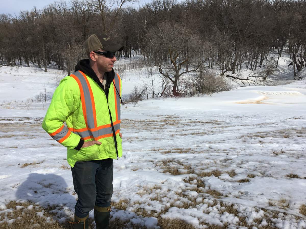 Jason Parker standing on the dyke that protects his family's home from flooding from the Red River. 