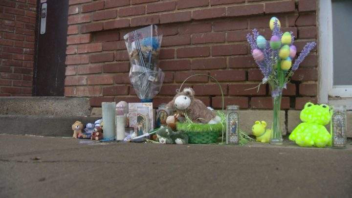 A small memorial has been set up outside the apartment where a toddler was reported unconscious.