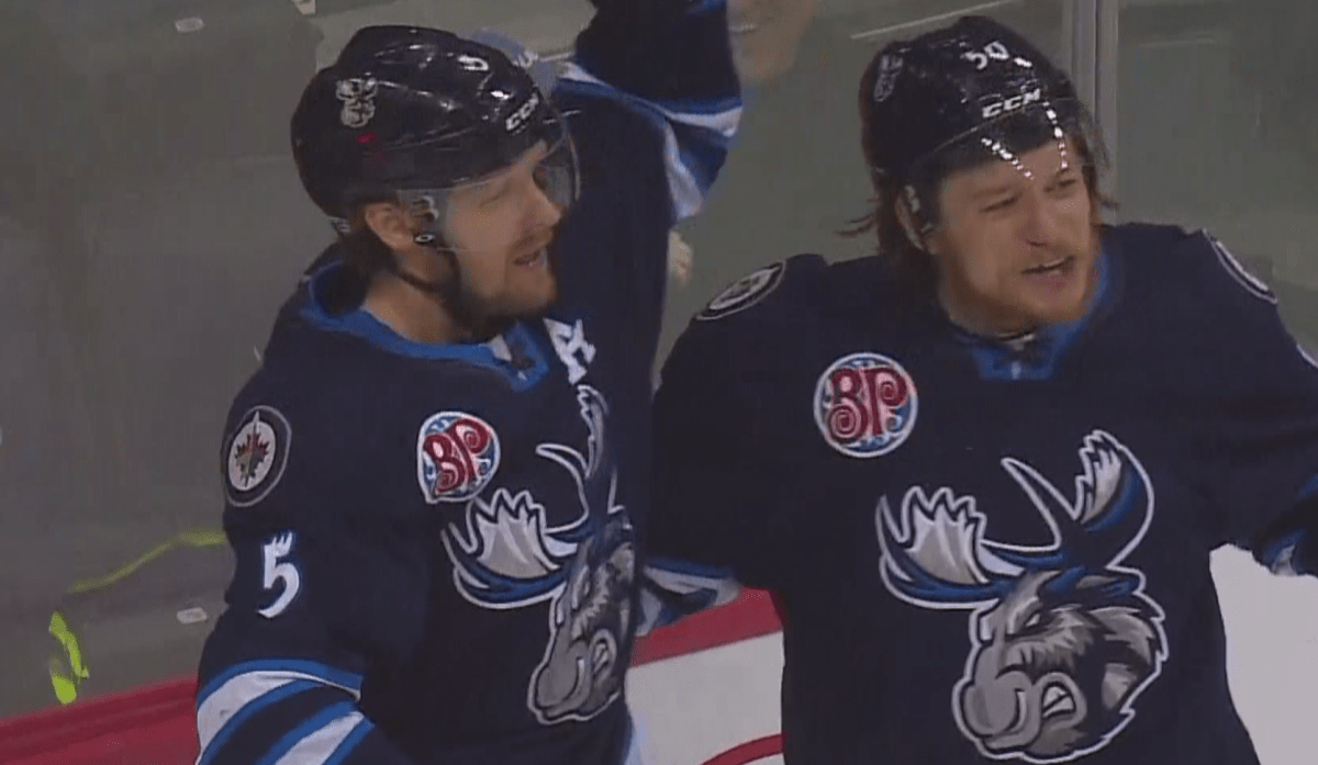 Cameron Schilling and Ryan White celebrate Manitoba's third goal of the game.