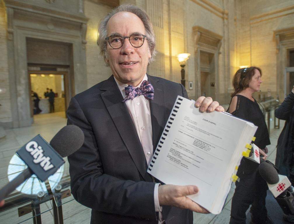 André Lesperance, one of the class action lawyers, holds up a copy of the decision by the Quebec Court of Appeal's to uphold a Superior Court ruling in two class-action lawsuits against three tobacco companies, Friday, March 1, 2019 in Montreal.