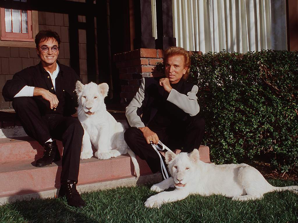 Siegfried and Roy pose with their white lions on January 18, 1996 in Los Angeles, Calif.