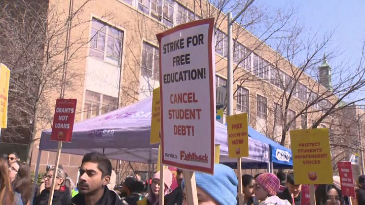 Protesters hold signs during the walkout at Ryerson on Wednesday at noon.