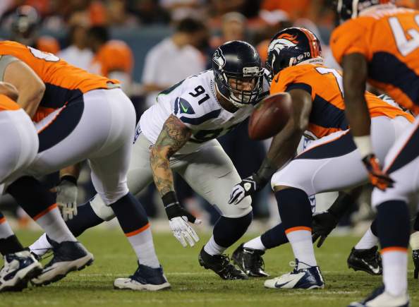 Defensive end Cassius Marsh #91 of the Seattle Seahawks rushes the line of scrimmage against offensive tackle Vinston Painter #70 of the Denver Broncos during preseason action at Sports Authority Field at Mile High on August 7, 2014, in Denver, Colorado. The Broncos defeated the Seahawks 21-16.