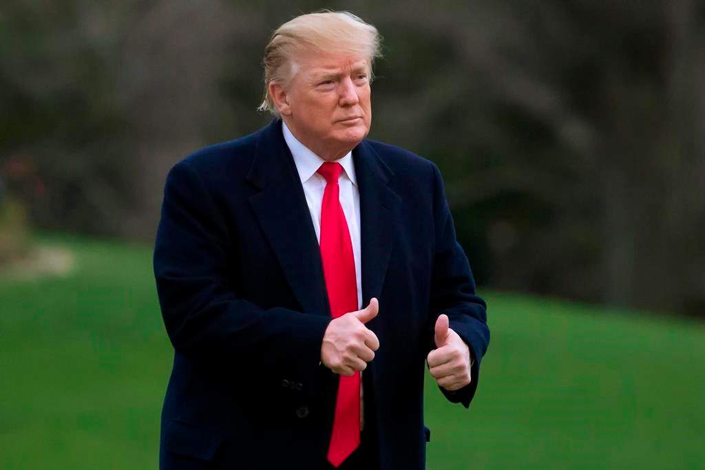 In this March 24, 2019, photo, President Donald Trump gives two thumbs up after stepping off Marine One on the South Lawn of the White House in Washington.