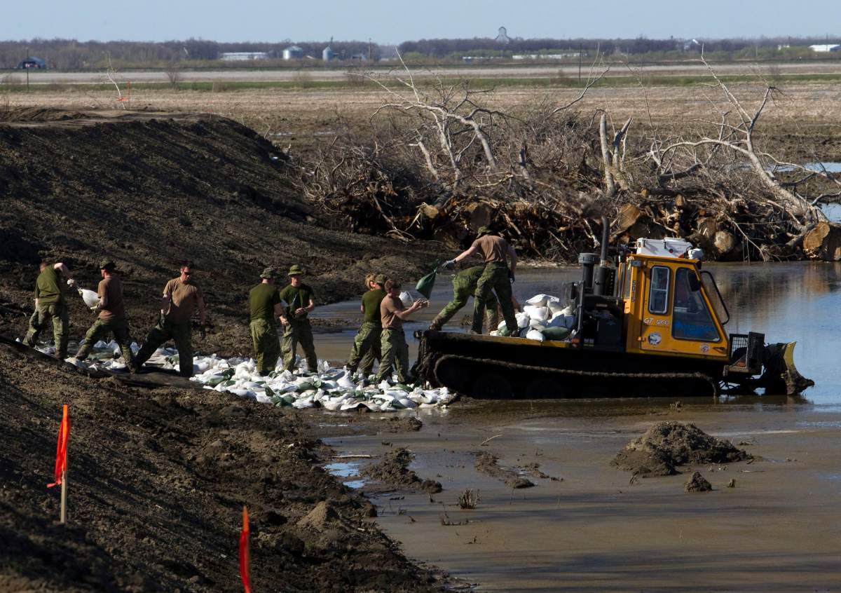 Canadian soldiers re-enforce a soft spot in the dike along the Assiniboine River on Sunday, May 15, 2011, in Poplar Point, Manitoba.