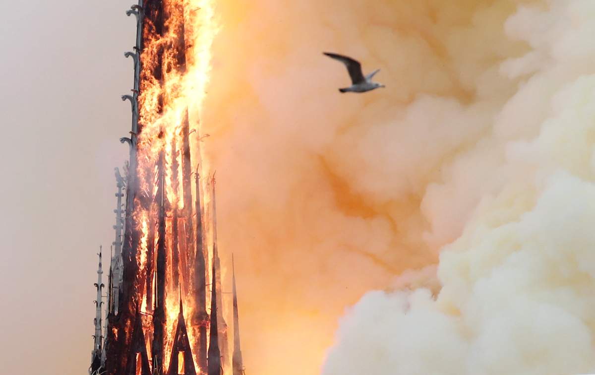 Smoke billows as fire engulfs the spire of Notre Dame Cathedral in Paris, France April 15, 2019.
