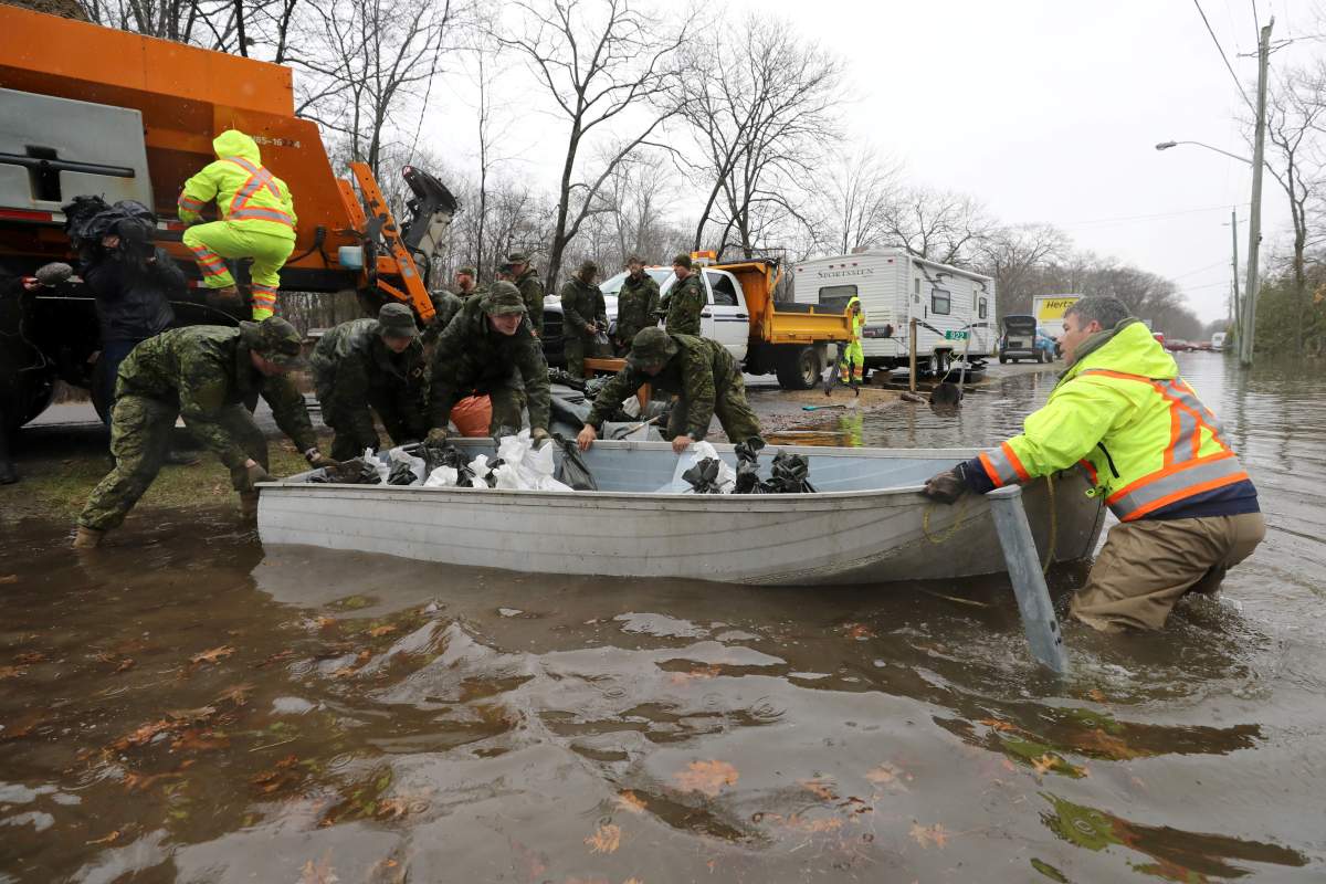 Members of the Canadian Forces help push a boat loaded with sandbags to a flooded home in the Constance Bay area in Ottawa, Ontario, Canada, April 26, 2019.  REUTERS/Chris Wattie