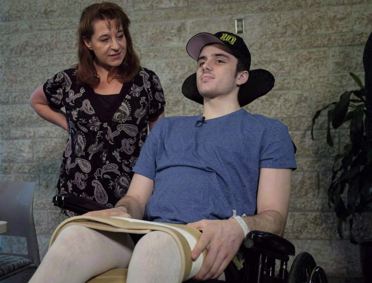 Humboldt Broncos hockey player Ryan Straschnitzki, who was paralyzed following a bus crash that killed 16 people, speaks to the media as his mother Michelle, looks on in Calgary, Alta., Wednesday, April 25, 2018. 
