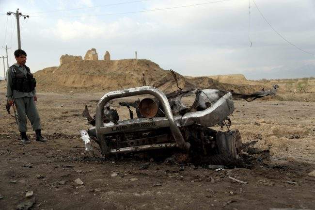 epaselect epa07493531 An Afghan soldier stands guard at the scene of a suicide bomb attack near Bagram airbase on the outskirts of Kabul, Afghanistan, April 9, 2019.