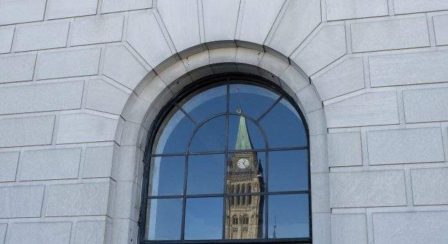 The Peace tower is reflected in a window in Ottawa, Tuesday March 26, 2019. 

