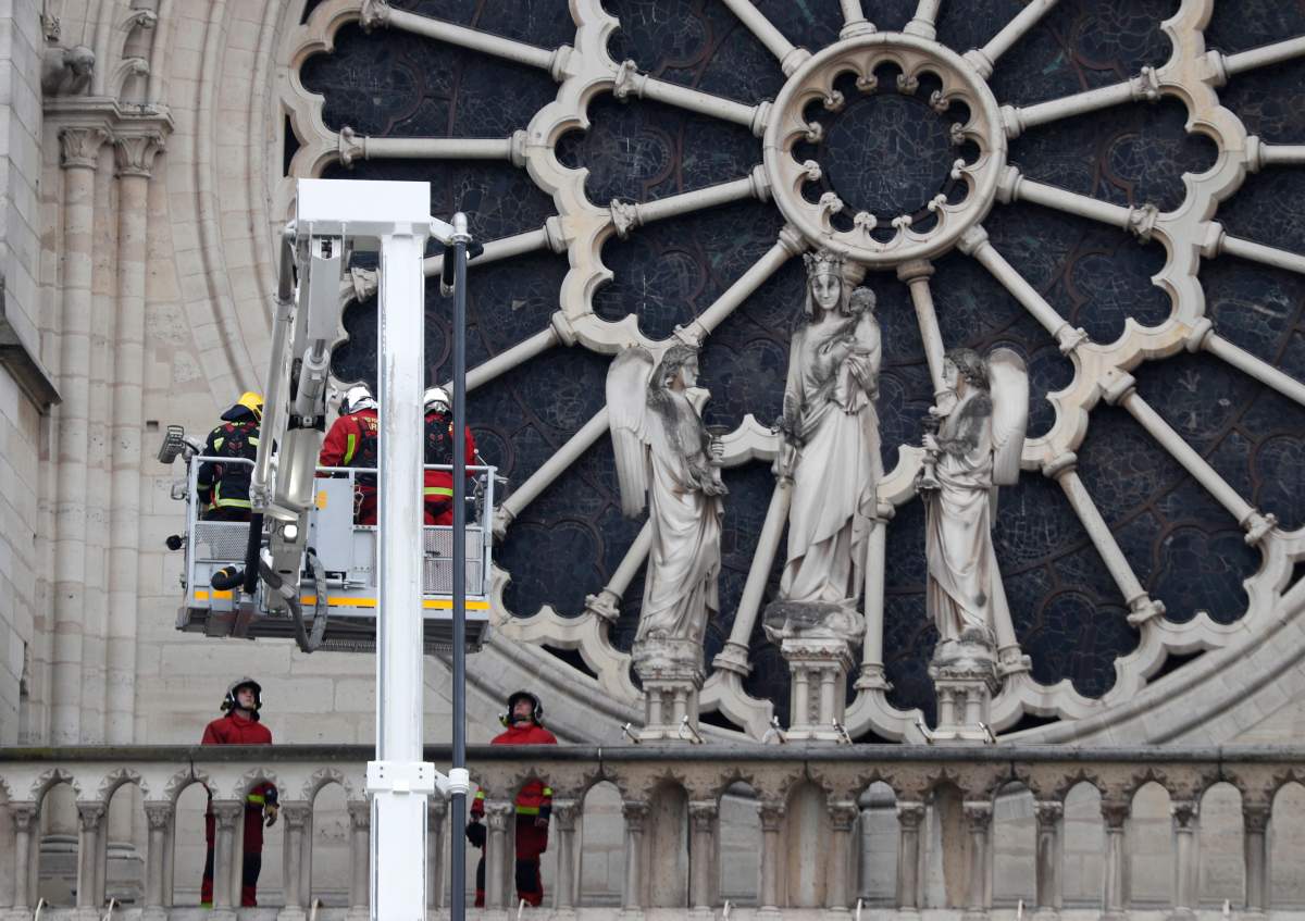 Firefighters work near the rose window of Notre Dame cathedral Tuesday April 16, 2019 in Paris.