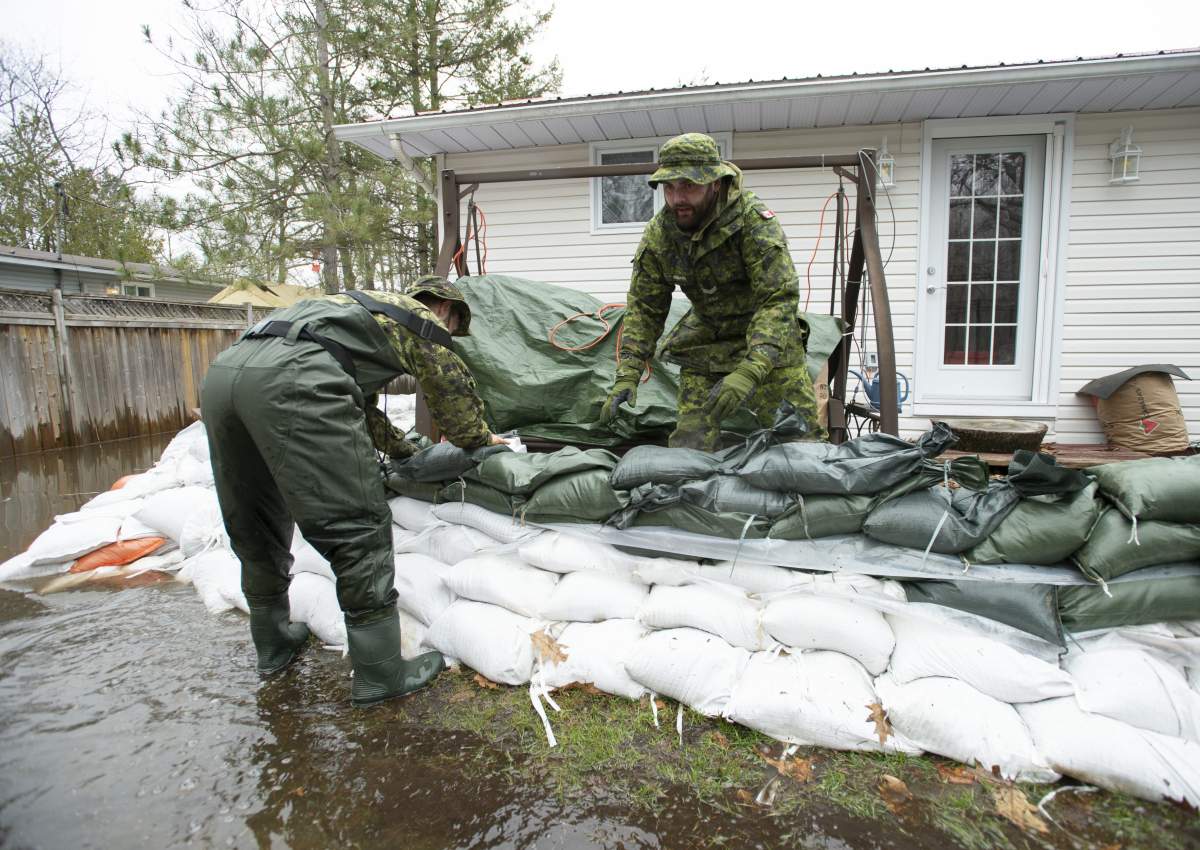 Canadian Forces members help build a wall of sandbags at a home in the Ottawa community of Constance Bay as flooding continues to affect the region, on Saturday, April 27, 2019.