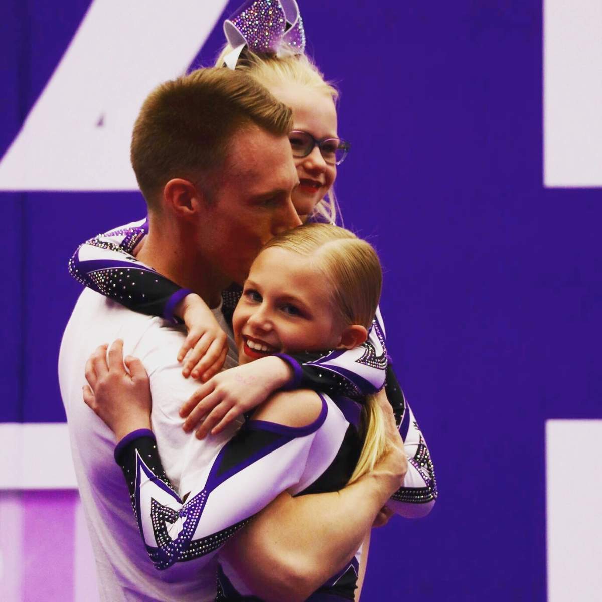 Marc Kennedy celebrates with his daughters after his cheer-leading debut with the Perfect Storm weathermen