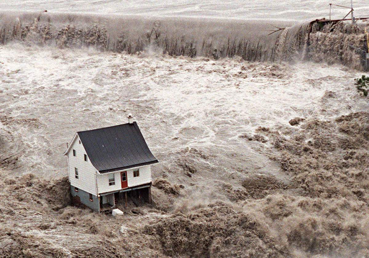 An aerial view of an overflooded dam on the Chicoutimi River on July 21, 1996, shows a house resisting a major flood in Saguenay.