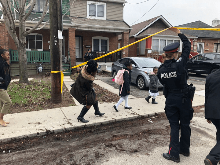 People pass under yellow tape to go celebrate Easter mass after a shooting near their church early Sunday.