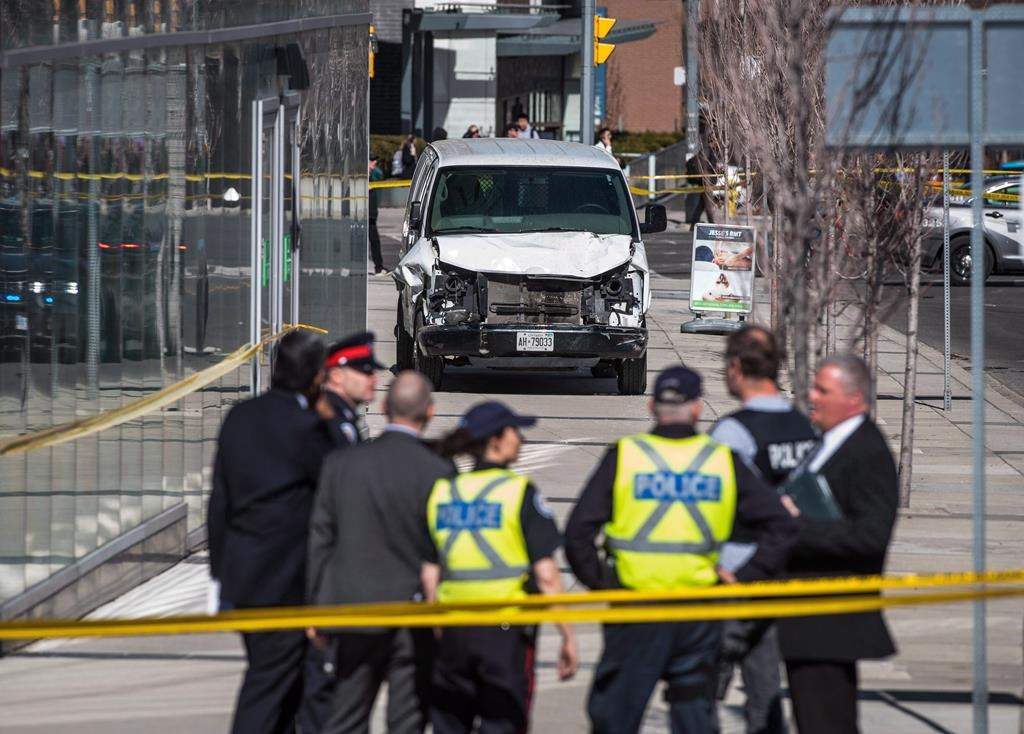 Police are seen near a damaged van in Toronto after a van mounted a sidewalk, crashing into a number of pedestrians on Monday, April 23, 2018. THE CANADIAN PRESS/Aaron Vincent Elkaim