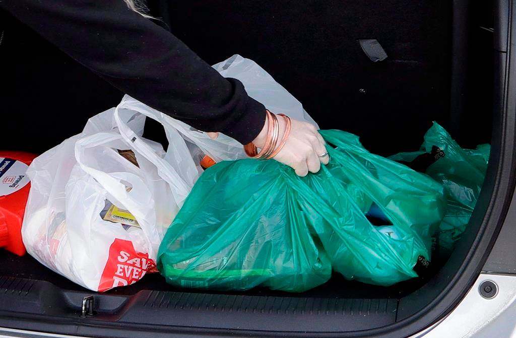 A shopper places her goods into her car outside a supermarket in Christchurch, New Zealand, Friday, Aug. 10, 2018. Newfoundland and Labrador has announced it will become the second province to ban plastic bags.