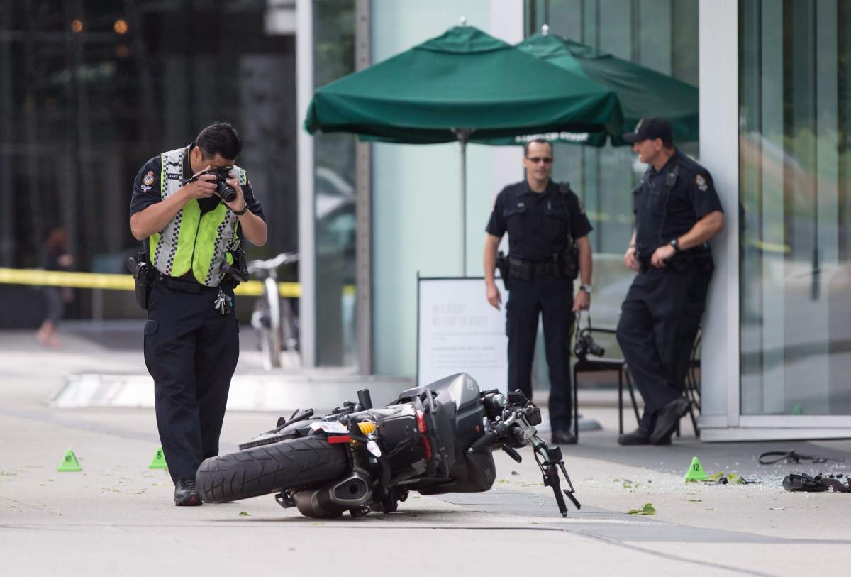 A police officer photographs a motorcycle after a female stunt driver working on the movie "Deadpool 2" died after a crash on set, in Vancouver, B.C., on Monday August 14, 2017. The studio behind the film has settled with the family of S.J. "Joi" Harris.