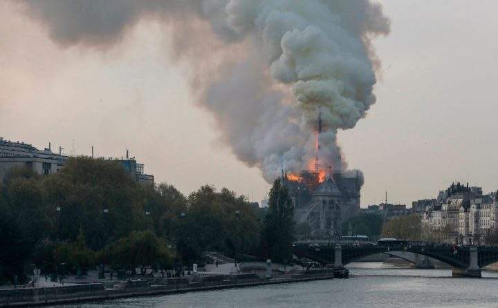 Smoke ascends as flames rise during a fire at the landmark Notre-Dame Cathedral in central Paris.