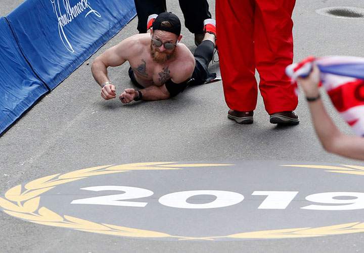 Micah Herndon, a former Marine from Ohio, crawls down Boylston Street towards the finish line of the 123rd Boston Marathon on April 15, 2019.