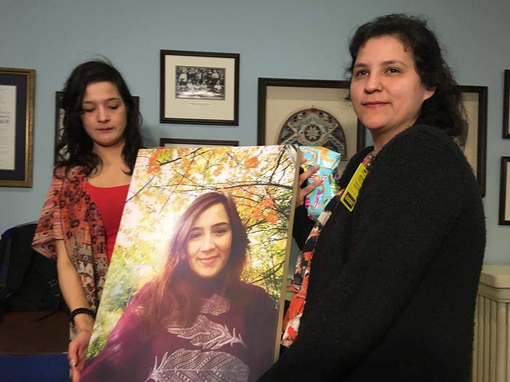 Tyra Denny, left, and Renee Denny hold a photo of their sister Cassidy Bernard at the Nova Scotia legislature in Halifax on Thursday, April 11, 2019. THE CANADIAN PRESS/Michael MacDonald