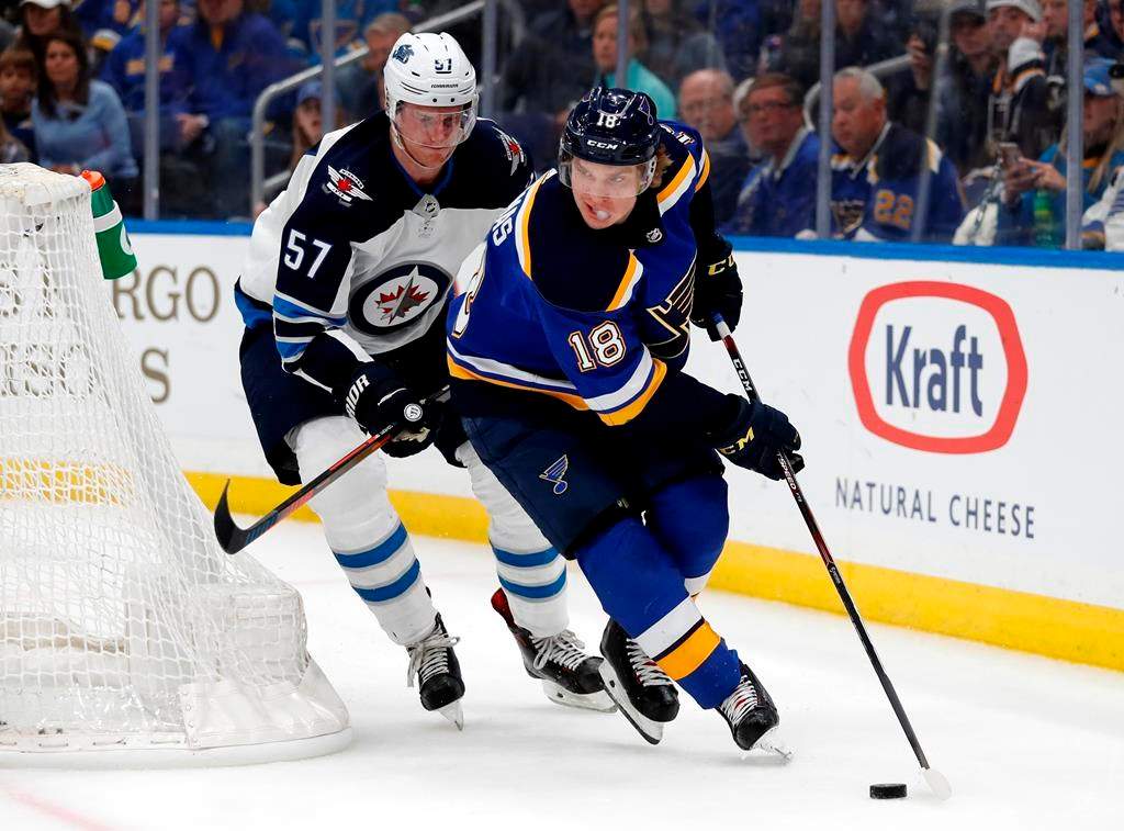 St. Louis Blues' Robert Thomas (18) handles the puck as Winnipeg Jets' Tyler Myers (57) defends during the second period in Game 3 of an NHL first-round hockey playoff series Sunday, April 14, 2019, in St. Louis. (AP Photo/Jeff Roberson).