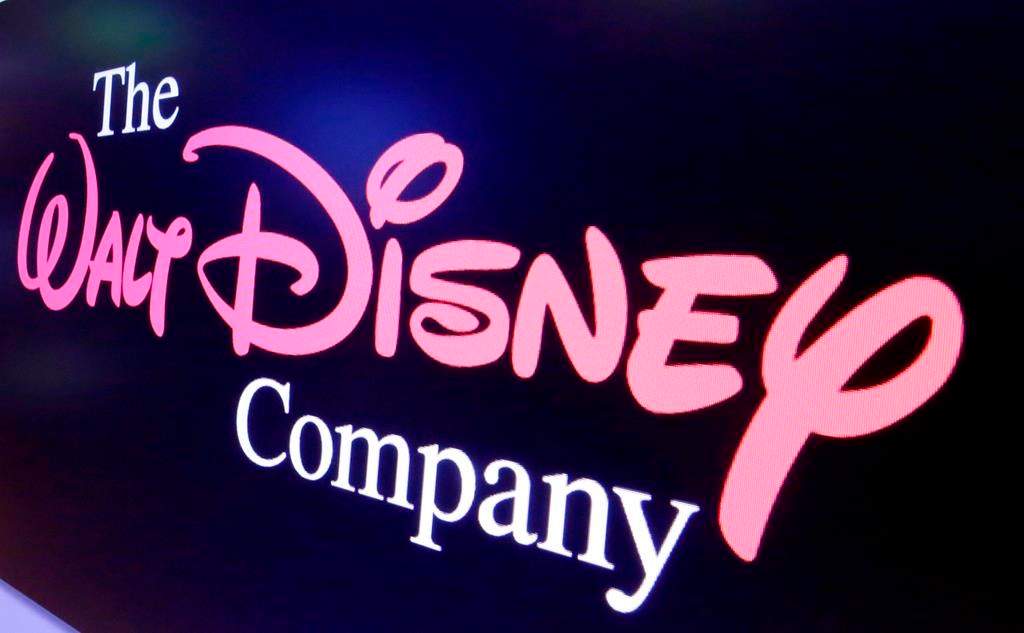 FILE - In this Aug. 7, 2017, file photo, The Walt Disney Co. logo appears on a screen above the floor of the New York Stock Exchange.