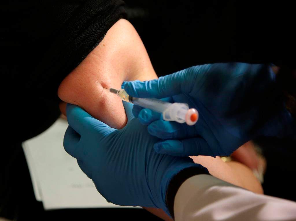 FILE - In this March 27, 2019, file photo, a woman receives a measles, mumps and rubella vaccine.