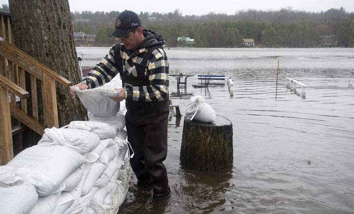 Stephen Wood places sandbags outside his property during flooding on Friday, April 26, 2019 in Ottawa. Adrian Wyld / The Canadian Press