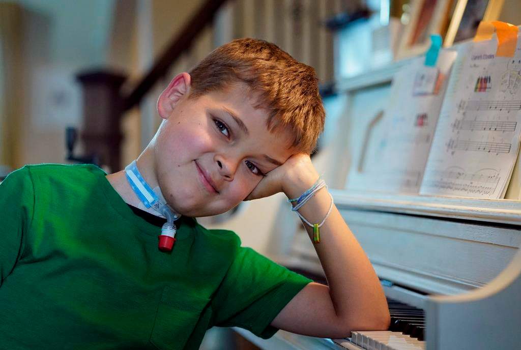 Braden Scott smiles after practicing on the piano in Tomball, Texas on Friday, March 29, 2019. Braden was diagnosed with the mysterious syndrome called acute flaccid myelitis, or AFM, in 2016 and was paralyzed almost completely. But since then he has recovered much of his muscle function. His parents believe a lot of it has to do with thousands of hours of physical therapy. (AP Photo/David J. Phillip)