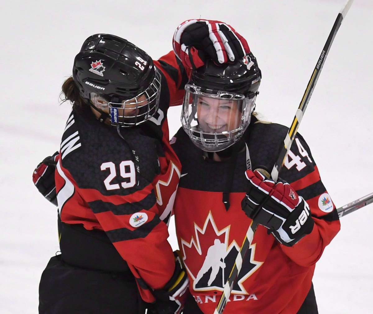 Canada's Marie-Philip Poulin (29) and Sarah Potomak (44) celebrate after defeating Russia in IIHF Ice Hockey Women's World Championship preliminary round action in Plymouth, Mich., on Monday, April 3, 2017. 