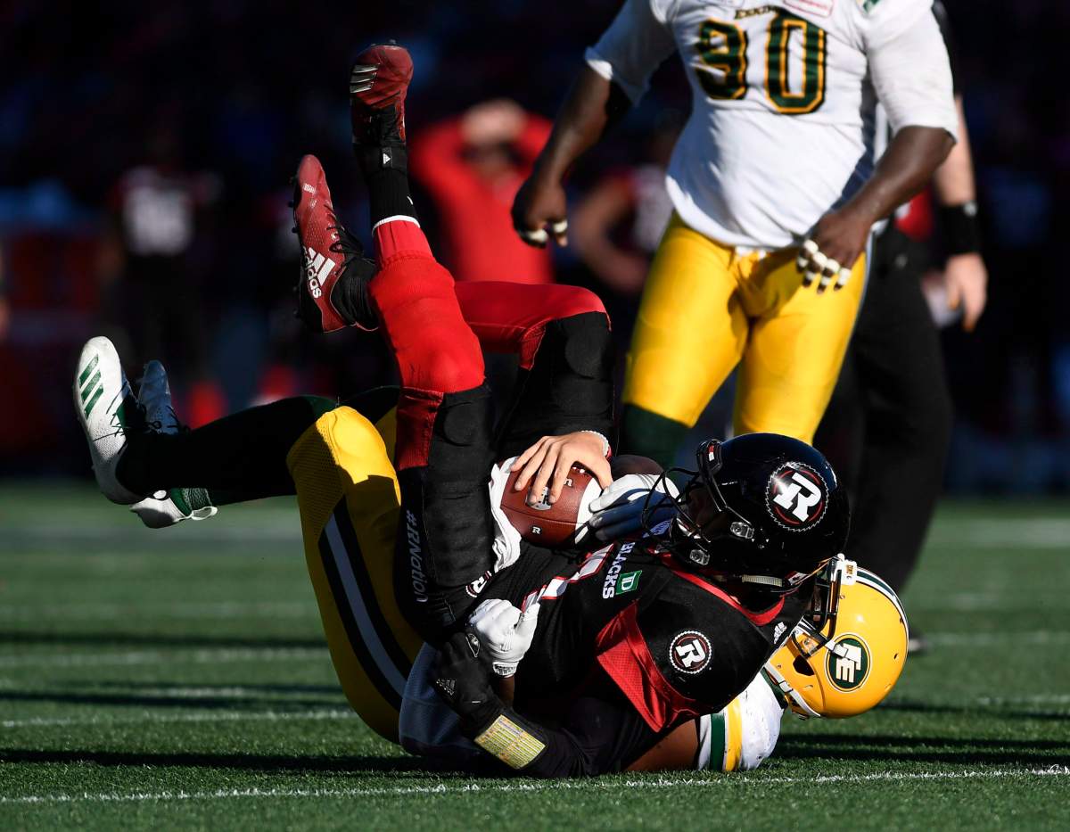 Ottawa Redblacks quarterback Trevor Harris (7) gets sacked by Edmonton Eskimos defensive end Kwaku Boateng (93) during first half CFL football action in Ottawa on Saturday, Sept. 22, 2018. THE CANADIAN PRESS/Justin Tang