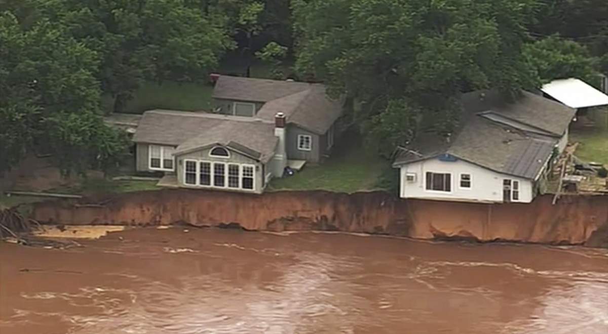 This image taken from video provided by KOCO-5 shows homes dangerously close to the Cimarron River on Wednesday, May 22, 2019 near Crescent, Oka. Waterlogged parts of the central U.S. were bracing Wednesday for more rain, following days of severe storms that have battered Iowa, Kansas, Missouri and Oklahoma.