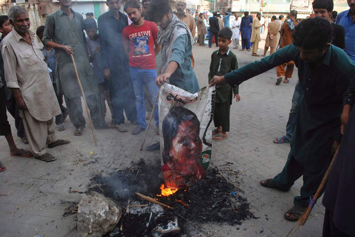 In this Nov. 1, 2018, file photo, Pakistani protesters burn a poster image of Christian woman Asia Bibi, in Hyderabad, Pakistan.