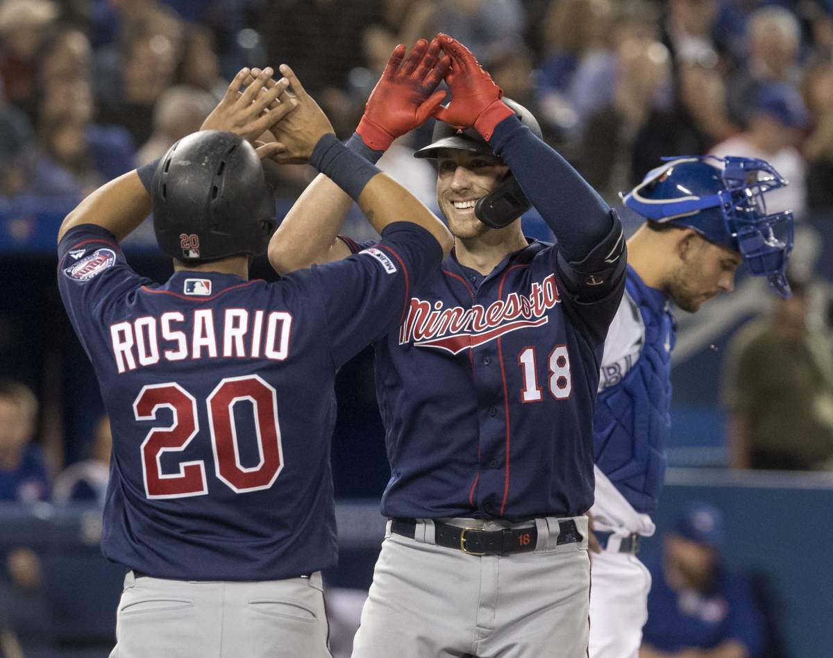 Minnesota Twins’ Mitch Garver high fives with teammate Eddie Rosario after Garver hit a two run home run against the Toronto Blue Jays in the sixth inning of their American League MLB baseball game in Toronto Tuesday May 7, 2019. THE CANADIAN PRESS/Fred Thornhill