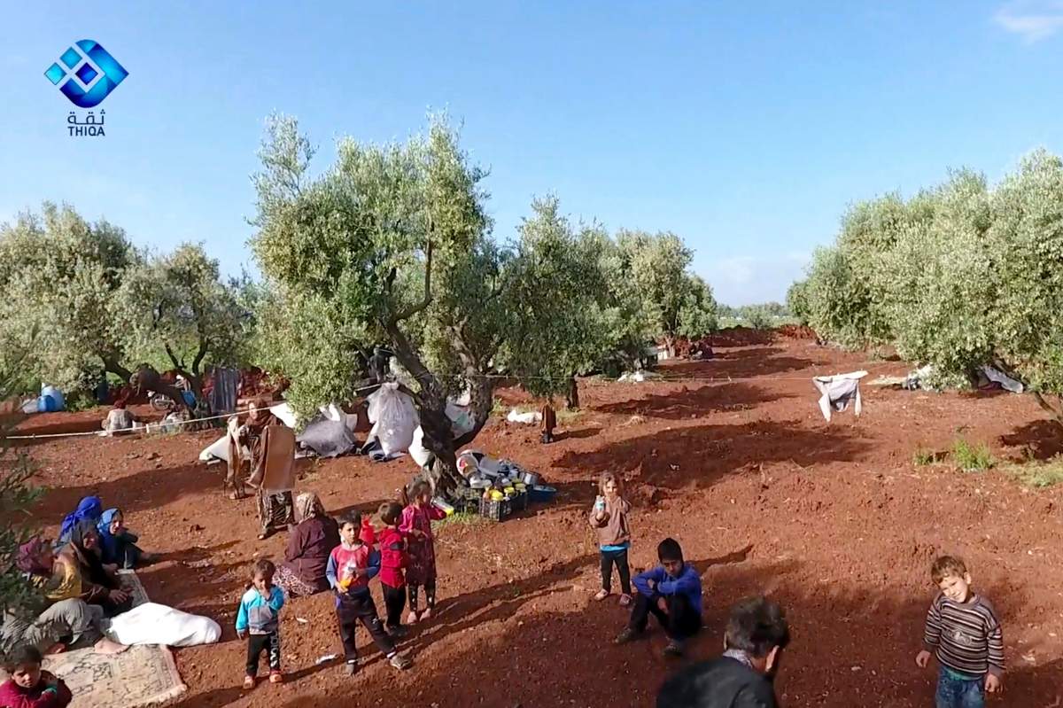 This frame grab from video provided by the activist-operated Thiqa News Agency, shows residents displaced from the latest violence that hit the last rebel stronghold, taking refuge in olives orchids near the town of al-Atmeh, in northern Idlib, Syria, Thursday, May 9, 2019.
